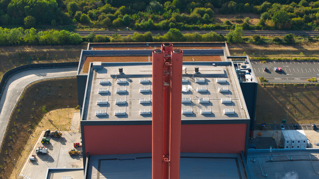Aerial view of the Rookery South ERF facility featuring its prominent red chimney stack flat roof with skylights and surrounding industrial grounds in Stewartby England United Kingdom. Aerial view of the Rookery South ERF facility featuring its prominent red chimney stack flat roof with skylights and surrounding industrial grounds in Stewartby England United Kingdom.