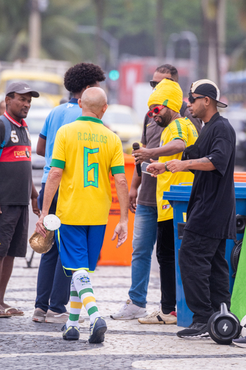 Rio de Janeiro Brazil 13 June 2026 View of a man in a Brazil football jersey holding a trophy replica while walking among fans on a patterned sidewalk during the World Cup 2026.