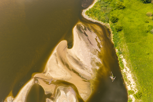 Aerial view of Vistula River with sandbanks and lush green riverbanks in Tczew Pomeranian Voivodeship Poland.