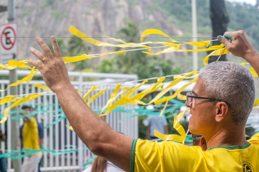 Rio de Janeiro Brazil 13 June 2026 View of a man in a yellow Brazil jersey hanging green and yellow ribbons on a wire in preparation for the World Cup 2026.