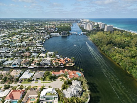 Aerial view of the Intracoastal waterway with luxury waterfront homes lush greenery and the Atlantic Ocean coastline in Boca Raton Florida United States. Aerial view of the Intracoastal waterway with luxury waterfront homes lush greenery and the Atlantic Ocean coastline in Boca Raton Florida United States.