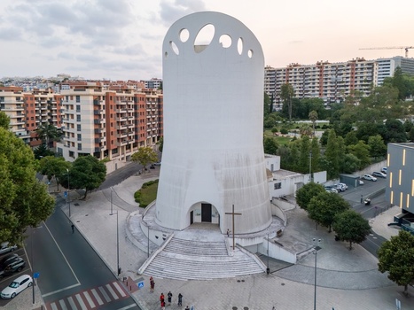 Alges Portugal 25 July 2026 Aerial view of Santissima Trindade Church a modern white cylindrical building with circular openings at the top surrounded by urban residential blocks and trees.