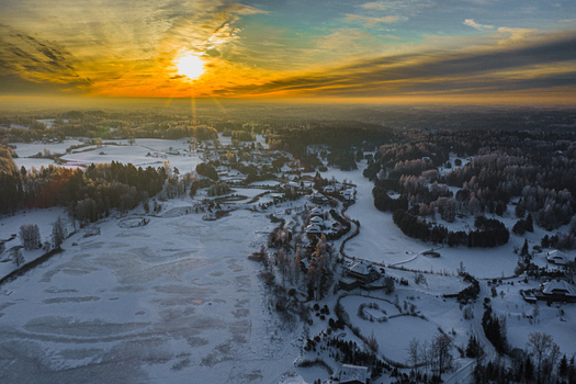 Aerial view of the snow covered landscape of Amatciems village with frozen lakes and forests at sunset located in Amatciems Cesu novads Latvia. Aerial view of the snow covered landscape of Amatciems village with frozen lakes and forests at sunset located in Amatciems Cesu novads Latvia.