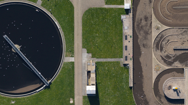 Aerial view of RWZI Geestmerambacht wastewater treatment plant with circular sedimentation tanks and aeration basins. Aerial view of RWZI Geestmerambacht wastewater treatment plant with circular sedimentation tanks and aeration basins.