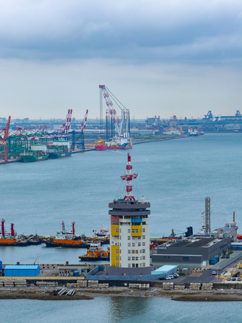 Aerial view of the control tower and industrial harbor facilities with cargo ships cranes and calm blue water in Taichung Taichung City Taiwan. Aerial view of the control tower and industrial harbor facilities with cargo ships cranes and calm blue water in Taichung Taichung City Taiwan.