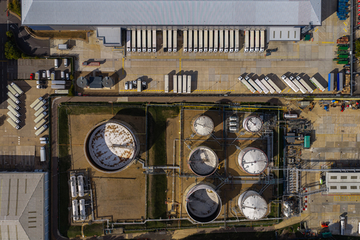 Aerial view of Hemel Hempstead Industrial Estate featuring a large warehouse with numerous loading bays and several circular industrial storage tanks in London England United Kingdom. Aerial view of Hemel Hempstead Industrial Estate featuring a large warehouse with numerous loading bays and several circular industrial storage tanks in London England United Kingdom.