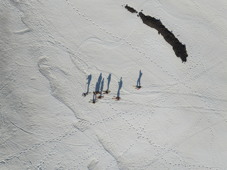 Aerial view of a group of skiers with long shadows on the snowy slopes of Mount Etna south side in Nicolosi Sicilia Italy. Aerial view of a group of skiers with long shadows on the snowy slopes of Mount Etna south side in Nicolosi Sicilia Italy.
