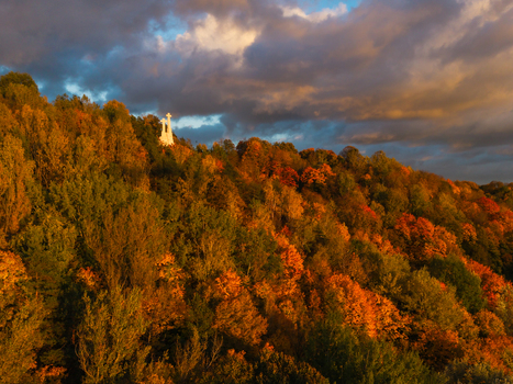Aerial view of the Three Crosses Monument stands silhouetted against a dramatic sky amidst a vibrant tapestry of autumn foliage Vilnius Lithuania. Aerial view of the Three Crosses Monument stands silhouetted against a dramatic sky amidst a vibrant tapestry of autumn foliage Vilnius Lithuania.
