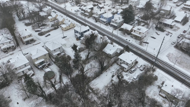 Aerial view of residential houses and a quiet road covered in a blanket of fresh snow in Lynchburg Virginia United States.