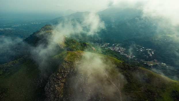 Aerial view of Mt. Gemi shrouded in mist with lush green slopes and the village of Amedzofe in the background Amedzofe Volta Region Ghana. Aerial view of Mt. Gemi shrouded in mist with lush green slopes and the village of Amedzofe in the background Amedzofe Volta Region Ghana.