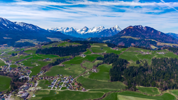 Aerial view of the vibrant green valley floor meets the jagged snow capped peaks creating a stunning alpine contrast Windischgarsten Upper Austria Austria. Aerial view of the vibrant green valley floor meets the jagged snow capped peaks creating a stunning alpine contrast Windischgarsten Upper Austria Austria.