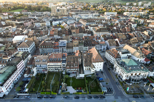 Aerial view of the historic town center with its traditional red tiled rooftops narrow streets and lush green gardens under soft evening light in Morges Vaud Switzerland. Aerial view of the historic town center with its traditional red tiled rooftops narrow streets and lush green gardens under soft evening light in Morges Vaud Switzerland.