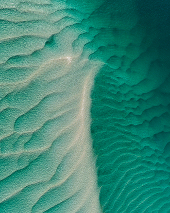 Aerial view of the turquoise waters and sandbanks of Moreton Bay showcasing the intricate ripple patterns in the sand at Amity Point Queensland Australia. Aerial view of the turquoise waters and sandbanks of Moreton Bay showcasing the intricate ripple patterns in the sand at Amity Point Queensland Australia.