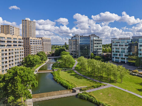 Aerial view of Lakeside Drive featuring a modern canal lush green parkland and surrounding contemporary residential and office buildings London England United Kingdom. Aerial view of Lakeside Drive featuring a modern canal lush green parkland and surrounding contemporary residential and office buildings London England United Kingdom.