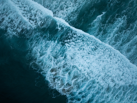 Aerial view of a powerful ocean wave breaking with white foam and deep blue water at La Jolla Cove San Diego California United States. Aerial view of a powerful ocean wave breaking with white foam and deep blue water at La Jolla Cove San Diego California United States.