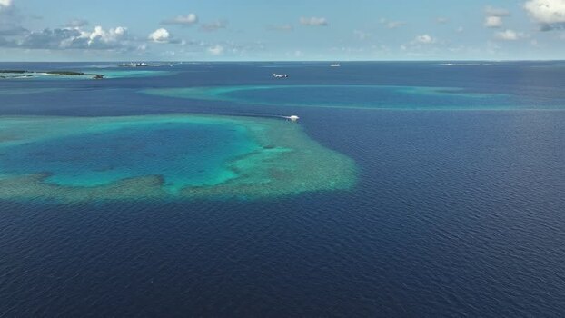 Aerial view of turquoise coral reefs and a boat in the ocean Maldives. Aerial view of turquoise coral reefs and a boat in the ocean Maldives.