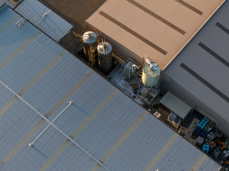 Melbourne VIC Australia 22 September 2026 Aerial view of industrial factories in Kilsyth with metal rooftops storage silos and containers in the yard under golden hour light. Melbourne VIC Australia 22 September 2026 Aerial view of industrial factories in Kilsyth with metal rooftops storage silos and containers in the yard under golden hour light.
