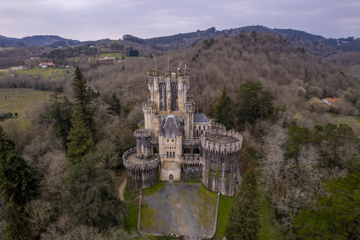 Aerial view of the historic Butron Castle surrounded by dense forest and rolling hills in Butroi Euskadi Spain. Aerial view of the historic Butron Castle surrounded by dense forest and rolling hills in Butroi Euskadi Spain.
