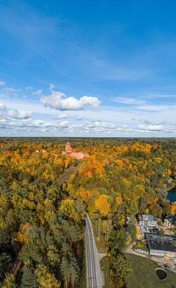 Aerial view of Sigulda Castle surrounded by vibrant autumn forest and a winding road in Sigulda Sigulda Municipality Latvia. Aerial view of Sigulda Castle surrounded by vibrant autumn forest and a winding road in Sigulda Sigulda Municipality Latvia.
