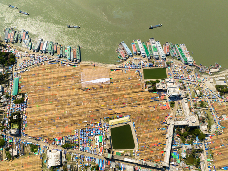 Aerial view of a bustling river port where cargo ships meet vibrant markets creating a tapestry of life and trade Charmonai Barisal Division Bangladesh. Aerial view of a bustling river port where cargo ships meet vibrant markets creating a tapestry of life and trade Charmonai Barisal Division Bangladesh.