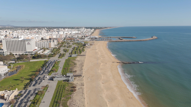 Aerial view of Vilamoura beach and the coastline with hotels a marina and sandy shores in Quarteira Faro District Portugal.
