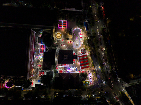 Aerial view of GOR Gelarsena Klaten Night Market with vibrant amusement rides stalls and red and white striped tents at night Kecamatan Klaten Utara Jawa Tengah Indonesia. Aerial view of GOR Gelarsena Klaten Night Market with vibrant amusement rides stalls and red and white striped tents at night Kecamatan Klaten Utara Jawa Tengah Indonesia.