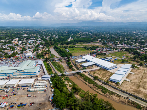 Aerial view of Ouanaminthe Market with large warehouses a river flowing through the urban landscape and surrounding buildings in Ouanaminthe Arrondissement Nord Est Department Haiti.