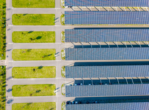 Aerial view of the Zonneweide solar carport featuring rows of solar panels over parking spaces with green grass strips in Harderwijk Gelderland Netherlands.