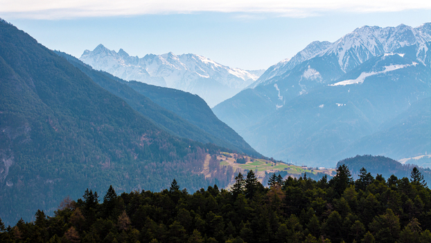 Aerial view of the snow capped Alpine peaks and lush coniferous forests overlooking the valley near Imst Tyrol Austria. Aerial view of the snow capped Alpine peaks and lush coniferous forests overlooking the valley near Imst Tyrol Austria.
