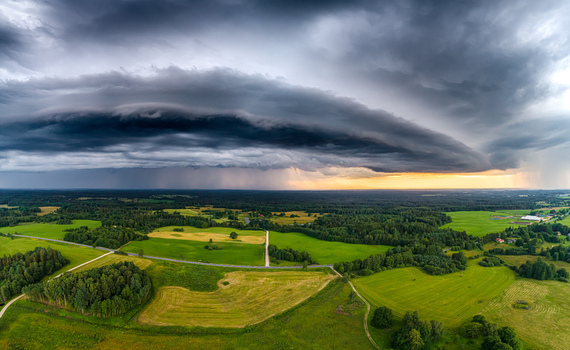 Aerial view of a dramatic supercell storm cloud formation over the lush green fields and forests of the Latvian countryside Latvia. Aerial view of a dramatic supercell storm cloud formation over the lush green fields and forests of the Latvian countryside Latvia.
