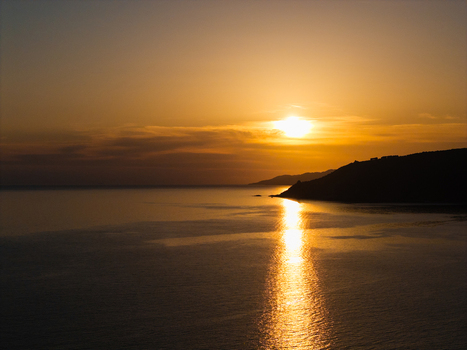 Aerial view of the sunset over the Tyrrhenian Sea with golden light reflecting on the water and the silhouette of the Cilento coastline in Pisciotta Campania Italy.