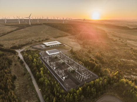 Aerial view of Eaglesham moor wind farm and electrical substation surrounded by dense forest and rolling hills under a warm sunset glow Kilmarnock Scotland United Kingdom.