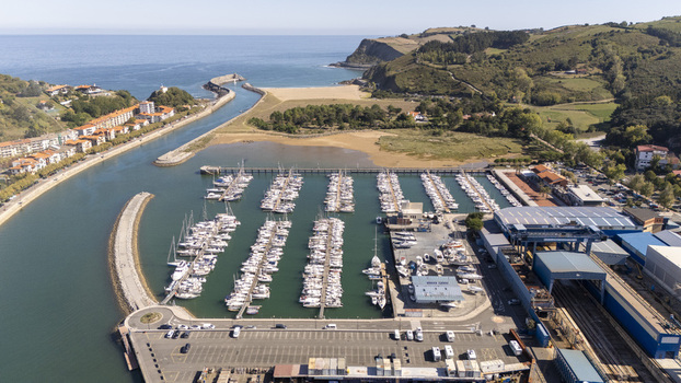 Aerial view of the marina in Zumaia with rows of docked boats a breakwater and surrounding green hills along the coast in Zumaia Basque Country Spain.