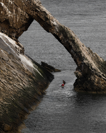 View of beautiful rocky arch and tranquil sea Portknockie Great Britain.