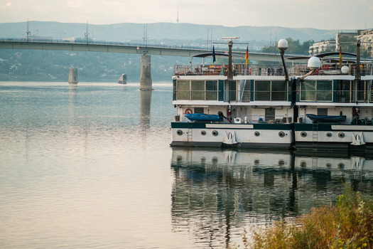 View of river cruise ships docked on the Danube river with the Varadin Bridge in the background in Novi Sad Vojvodina Serbia. View of river cruise ships docked on the Danube river with the Varadin Bridge in the background in Novi Sad Vojvodina Serbia.
