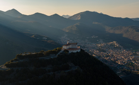 Aerial view of Santuario del Santissimo Salvatore perched on a hill overlooking the town and surrounding mountains during golden hour Montella Campania Italy. Aerial view of Santuario del Santissimo Salvatore perched on a hill overlooking the town and surrounding mountains during golden hour Montella Campania Italy.