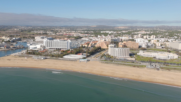 Aerial view of Vilamoura marina and beach with hotels resort buildings and sandy coastline in Quarteira Faro District Portugal.