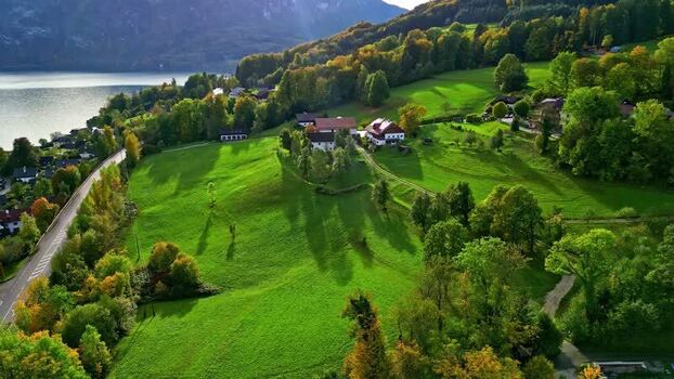 Aerial view of Attersee lake and green meadows Austria.