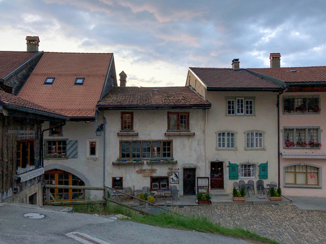 Gruyeres Switzerland 14 May 2026 View of traditional alpine houses with terracotta tiled roofs wooden shutters and a cobblestone street under a cloudy twilight sky. Gruyeres Switzerland 14 May 2026 View of traditional alpine houses with terracotta tiled roofs wooden shutters and a cobblestone street under a cloudy twilight sky.