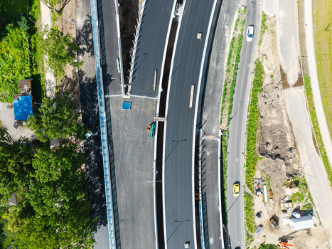 Aerial view of a new road construction site with fresh asphalt concrete barriers and surrounding greenery in Riga Latvia. Aerial view of a new road construction site with fresh asphalt concrete barriers and surrounding greenery in Riga Latvia.