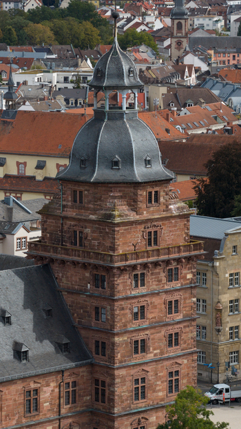 Aerial view of the historic Schloss Johannisburg with its distinctive red sandstone tower and slate roof rising above the urban cityscape of Aschaffenburg Bayern Germany.