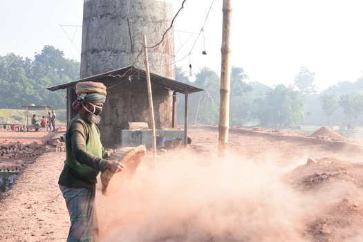 Kushtia District Bangladesh 28 November 2020 View of a worker wearing a face mask while sifting soil at a brick kiln in a rural area. Kushtia District Bangladesh 28 November 2020 View of a worker wearing a face mask while sifting soil at a brick kiln in a rural area.