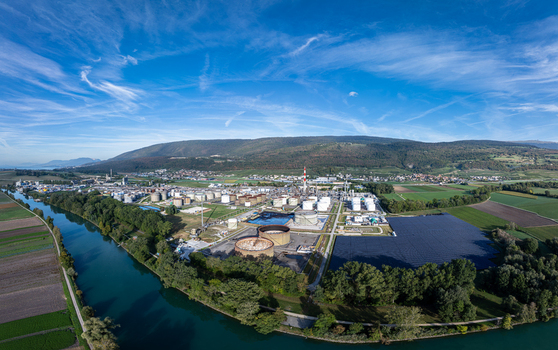 Aerial view of Cressier Refinery with industrial storage tanks processing units and tall chimney situated along the river in a rural landscape in Cornaux Neuchatel Switzerland. Aerial view of Cressier Refinery with industrial storage tanks processing units and tall chimney situated along the river in a rural landscape in Cornaux Neuchatel Switzerland.