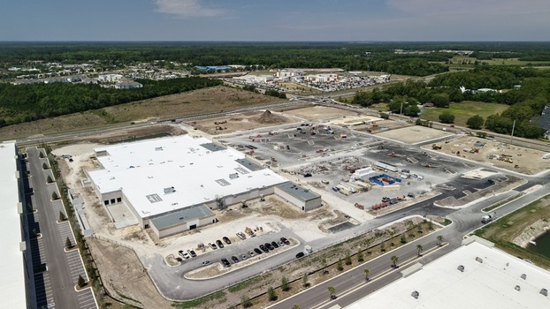 Aerial view of a large warehouse construction site with a white roof and parking area on Foundry Lane in World Golf Village Florida United States.