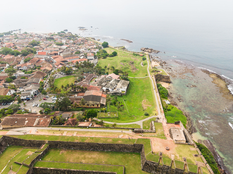 Aerial view of the historic Galle Fort ramparts and the old town with red tiled roofs along the rocky coastline in Galle Southern Province Sri Lanka. Aerial view of the historic Galle Fort ramparts and the old town with red tiled roofs along the rocky coastline in Galle Southern Province Sri Lanka.