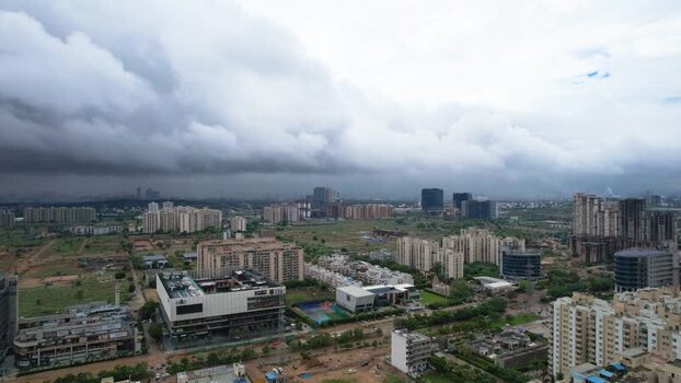 Aerial view of Gurugram skyscrapers under heavy monsoon clouds India.