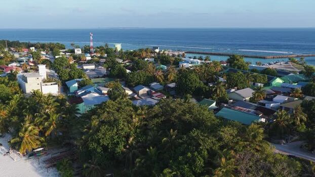 Aerial view of the coastal village and lush palms in Vashafaru Maldives. Aerial view of the coastal village and lush palms in Vashafaru Maldives.