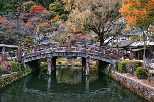 Nikko Japan 02 November 2025 View of Edo Wonderland Nikko Edomura featuring a traditional wooden arched bridge over a calm canal surrounded by autumn foliage. Nikko Japan 02 November 2025 View of Edo Wonderland Nikko Edomura featuring a traditional wooden arched bridge over a calm canal surrounded by autumn foliage.