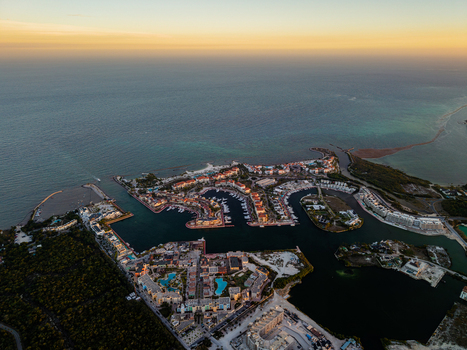 Aerial view of Cap Cana Marina featuring luxury villas docked boats and turquoise canals surrounded by lush vegetation at sunset in Punta Cana La Altagracia Provinc Dominican Republic. Aerial view of Cap Cana Marina featuring luxury villas docked boats and turquoise canals surrounded by lush vegetation at sunset in Punta Cana La Altagracia Provinc Dominican Republic.