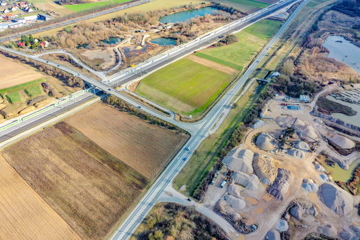 Aerial view of a highway interchange railway tracks and a gravel quarry surrounded by agricultural fields and small ponds in Forchheim Bavaria Germany. Aerial view of a highway interchange railway tracks and a gravel quarry surrounded by agricultural fields and small ponds in Forchheim Bavaria Germany.